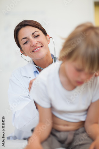 Doctor examining breathing of a child with a stethoscope