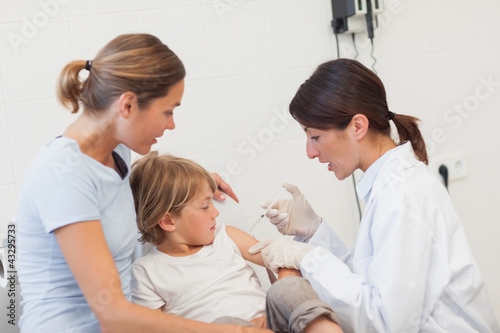 Child receiving an injection by a doctor