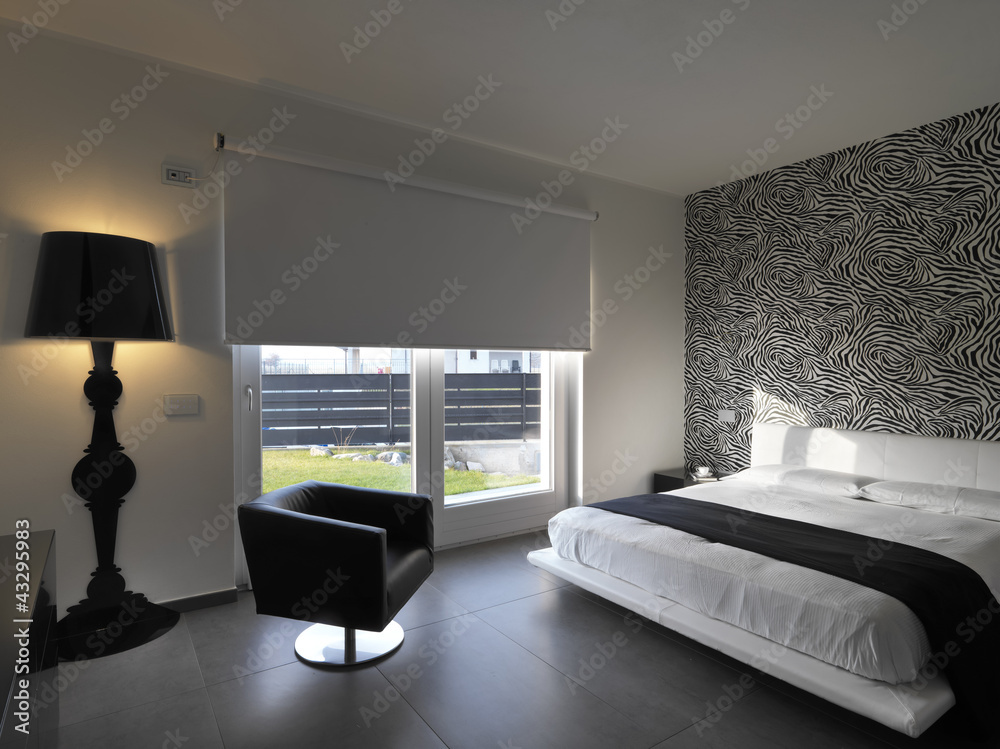 camera da letto moderna con poltrona in pelle nera Stock Photo
