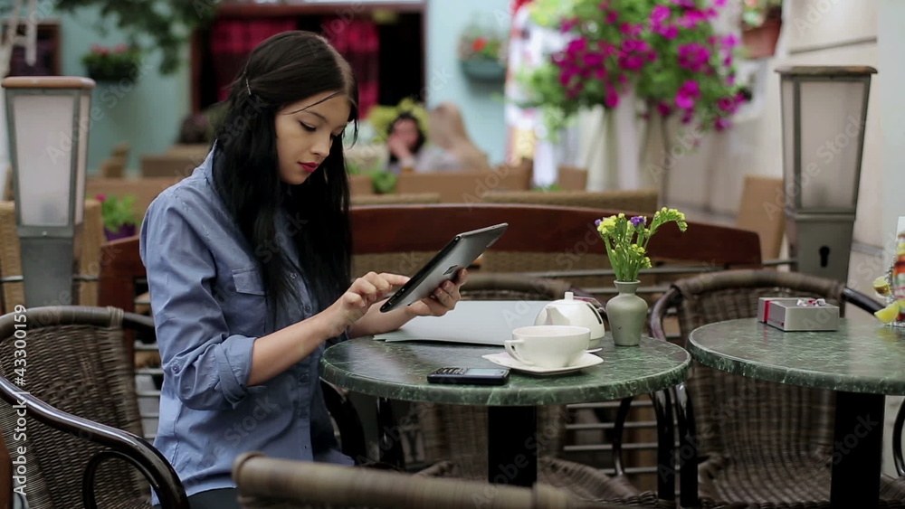 Young businesswoman working on tablet computer in cafe Young businesswoman working on tablet computer in cafe