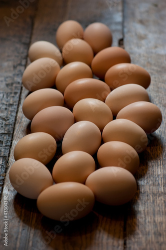 Brown eggs at wooden table background. Shallow depth of field