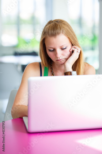 pretty female college student working on her laptop