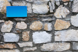 a blank blue metal signboard on a brick wall