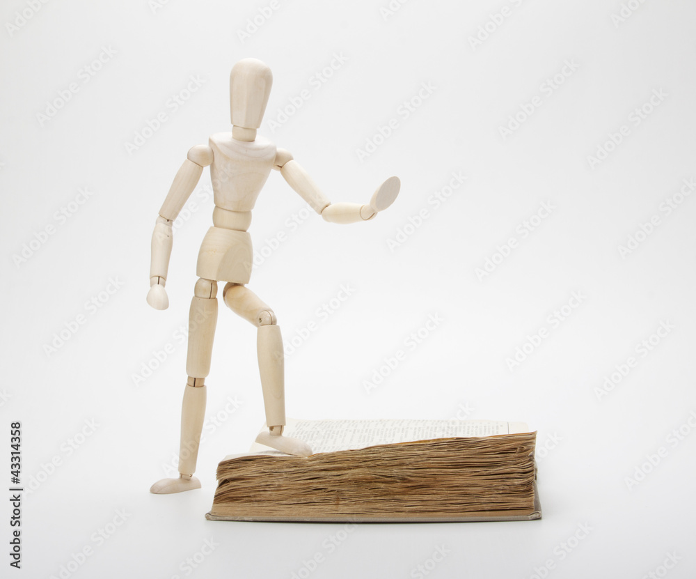 Wooden man and book, isolated on white Wooden man and book, isolated on white