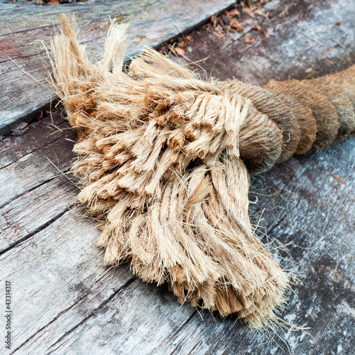 Фотография Frayed end of sisal rope lying on weathered wood