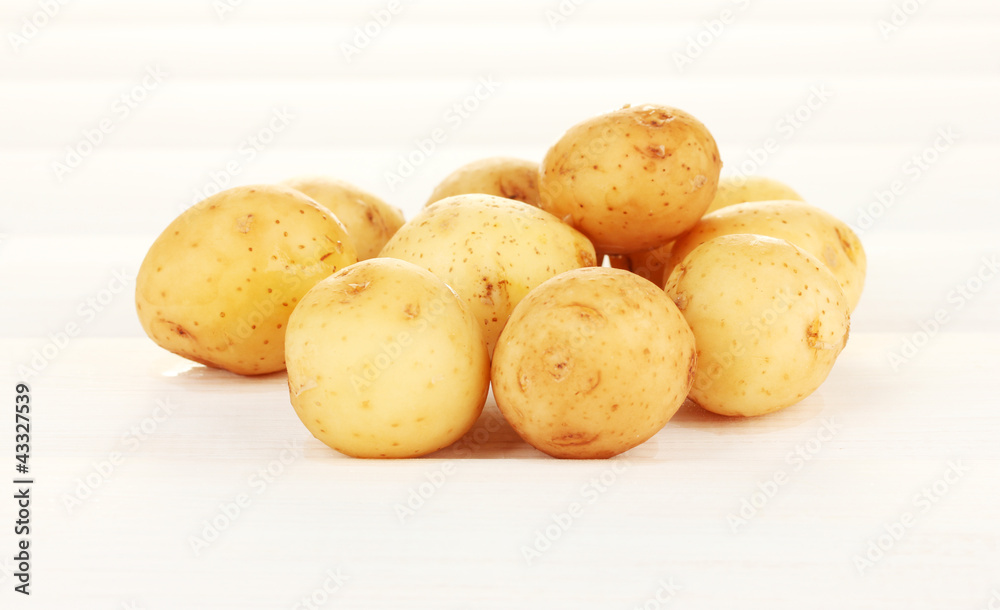 young potatoes on white wooden table close-up young potatoes on white wooden table close-up