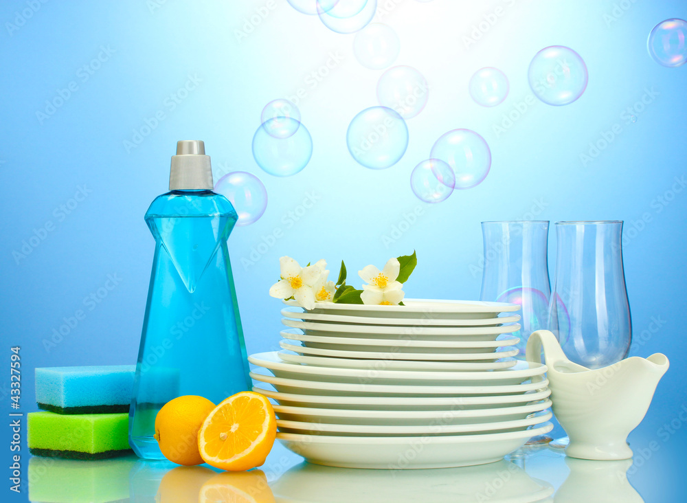 empty clean plates and glasses with dishwashing liquid, sponges Stock