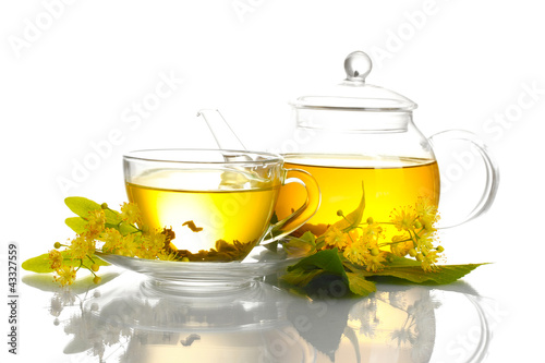 cup and teapot of linden tea and flowers isolated on white