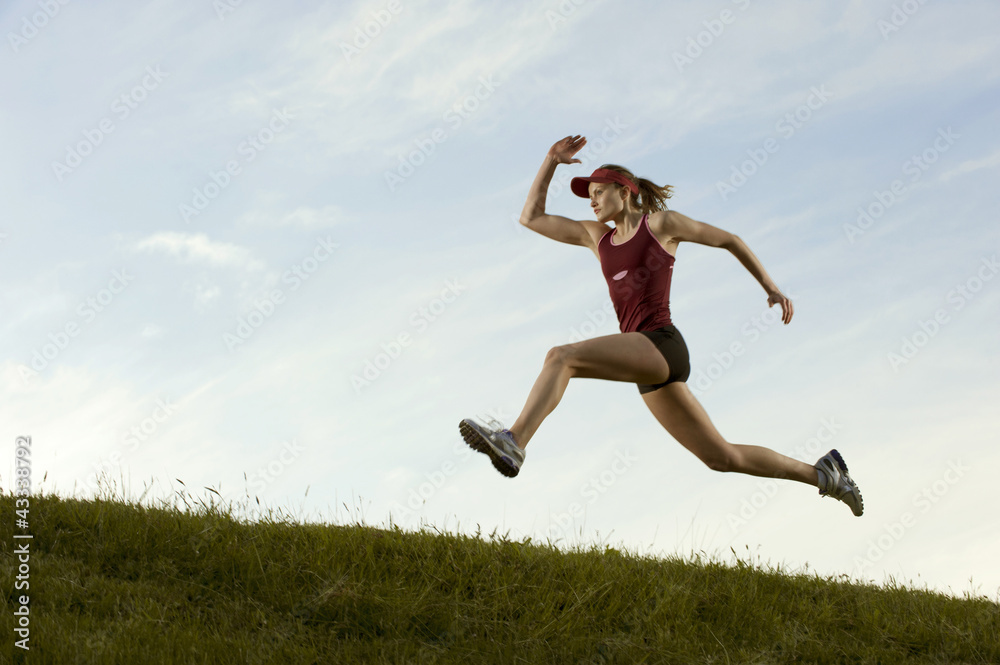 Caucasian runner running in field Caucasian runner running in field