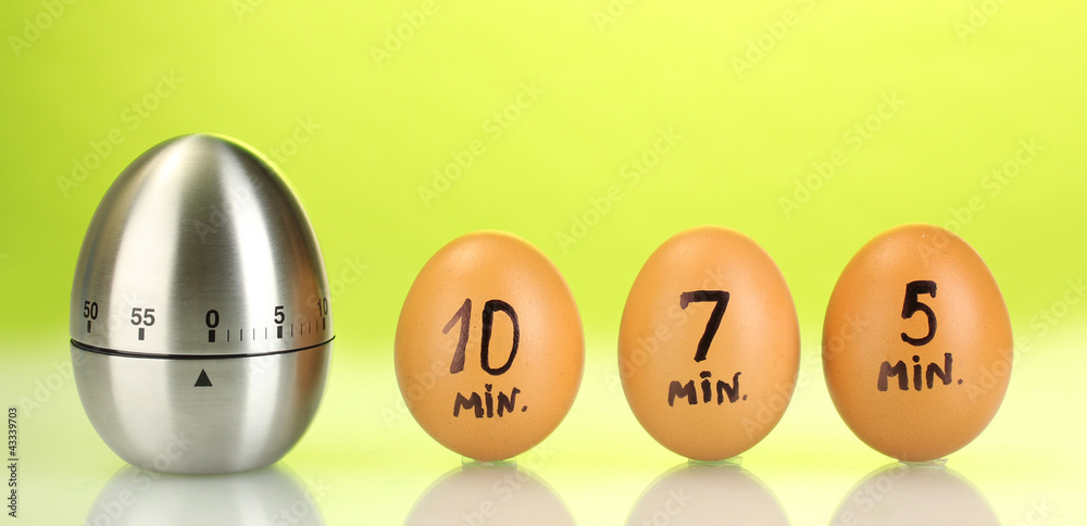 egg timer and eggs on green background egg timer and eggs on green background