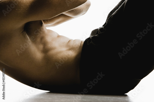 Caucasian man doing sit-ups