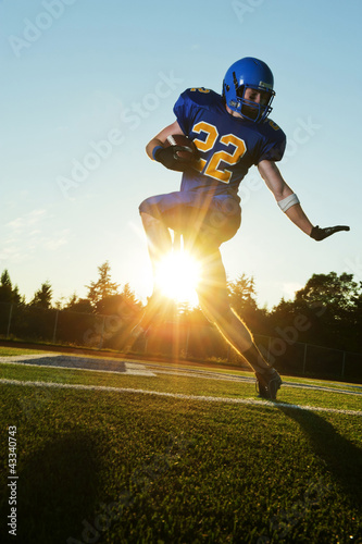Caucasian football player running with ball photo
