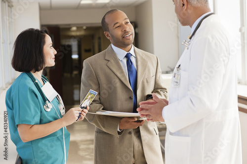 Doctors and drug salesman talking in hospital