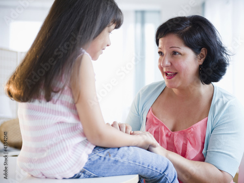 Hispanic mother comforting daughter photo