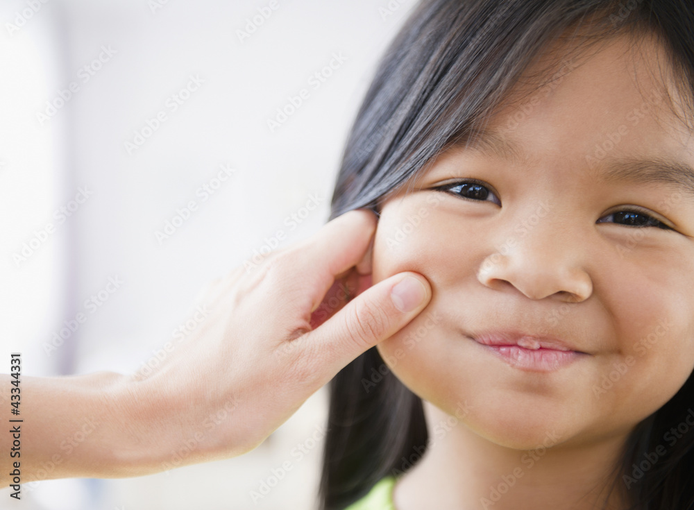 Mother pinching Korean girl's cheek Mother pinching Korean girl's cheek