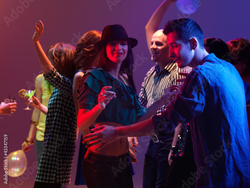 happy young people dancing in night club
