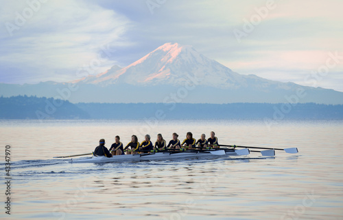 Team rowing boat in bay photo