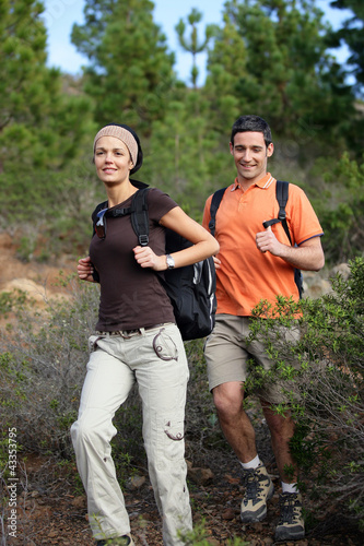 Young couple hiking through the woods