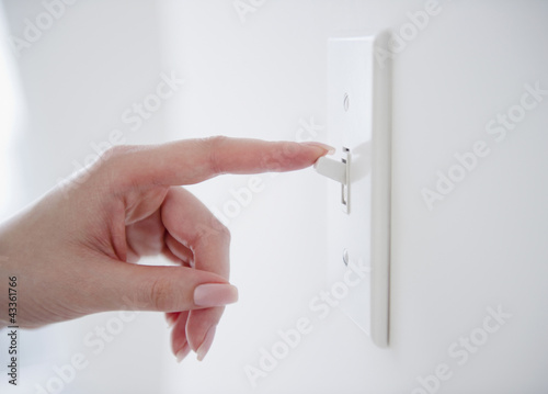 Korean woman turning off light switch