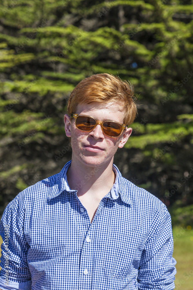 teenage boy with sunglasses walks happy on the meadow teenage boy with sunglasses walks happy on the meadow