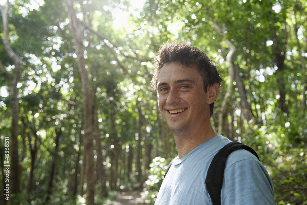 Smiling Caucasian man standing in forest Smiling Caucasian man standing in forest
