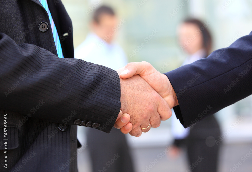 Closeup of business people shaking hands over a deal Closeup of business people shaking hands over a deal
