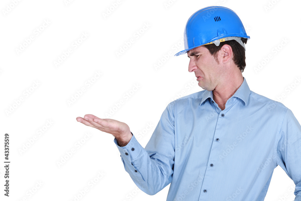 Man with a helmet disgusted by his hand
