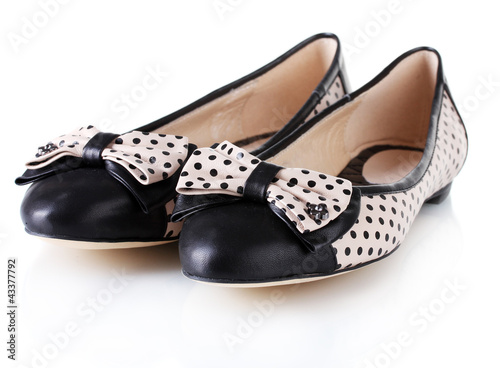 Female flat ballet shoes patterned with black polka dots