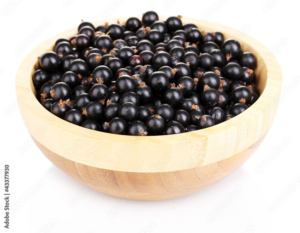 Black currant in wooden bowl isolated on white Black currant in wooden bowl isolated on white