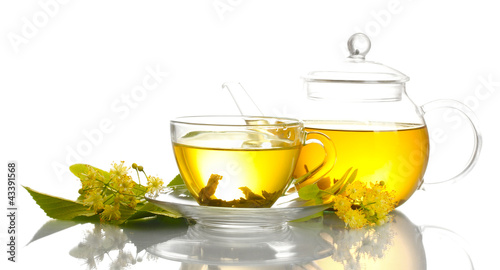 cup and teapot of linden tea and flowers isolated on white