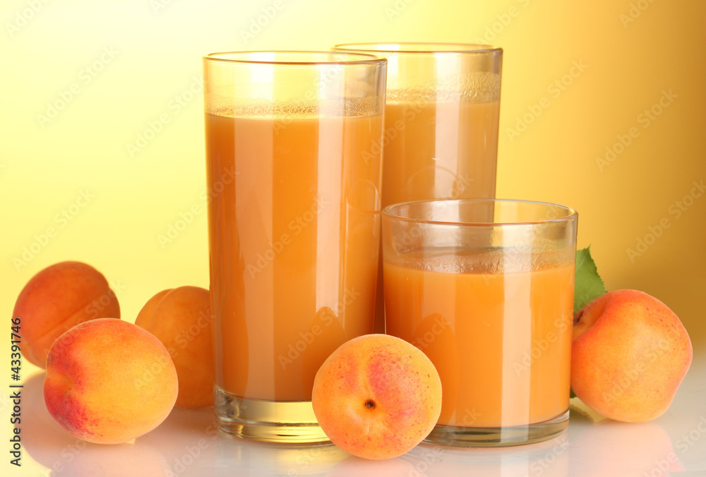 glasses of apricot juice on yellow background glasses of apricot juice on yellow background