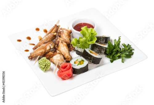 Buffalo chicken wings on plate with sushi