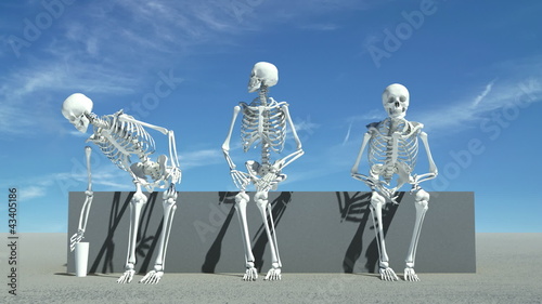 Three skeletons sitting down watching something,