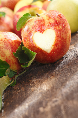 Delicious red apple with heart cutout photo