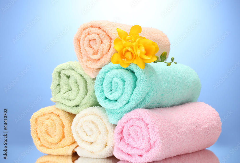 colorful towels and flowers on blue background colorful towels and flowers on blue background