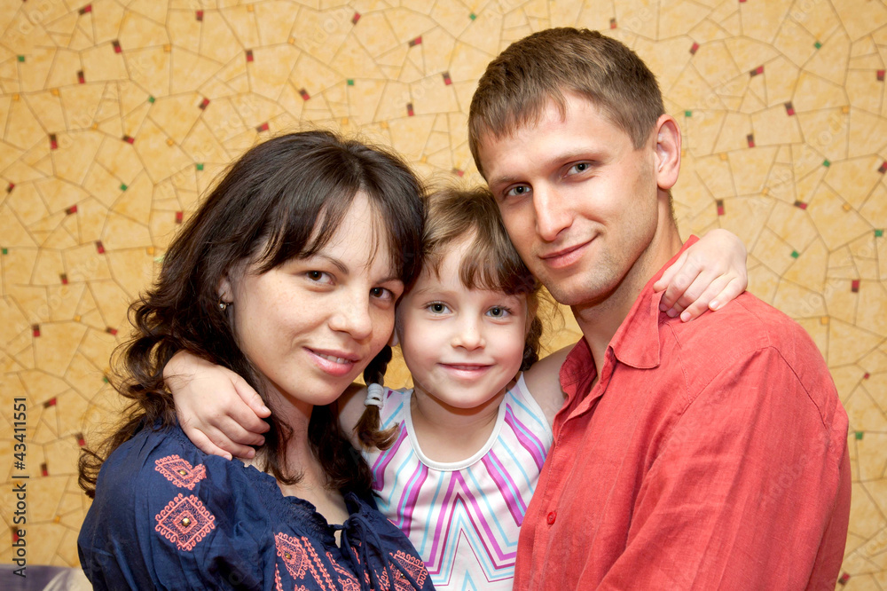 Fototapeta premium Father, mother and daughter hugging and smiling