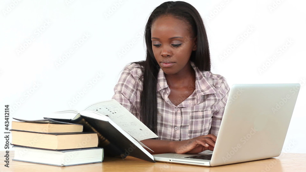 Woman reading books with a laptop Woman reading books with a laptop