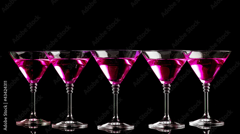 pink cocktails in martini glasses isolated on black