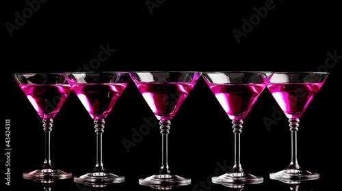 pink cocktails in martini glasses isolated on black