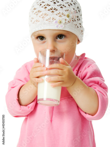 pretty little girl is holding a glass of milk