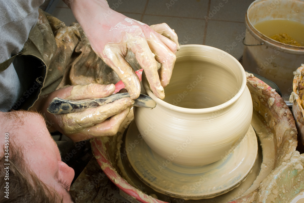 hands of a potter, creating an earthen jar on the circle