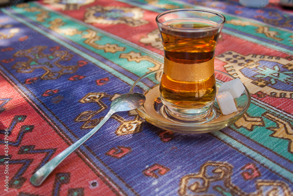 Glass of turkish tea  with sugar and spoon on the table in Istanbul city - obrazy, fototapety, plakaty 