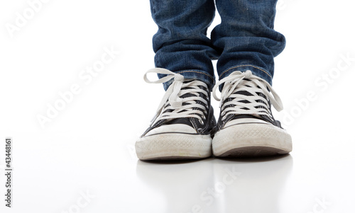 Vintage, antique athletic shoes on a white background with jeans