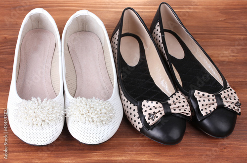two pairs female flat shoes on wooden background