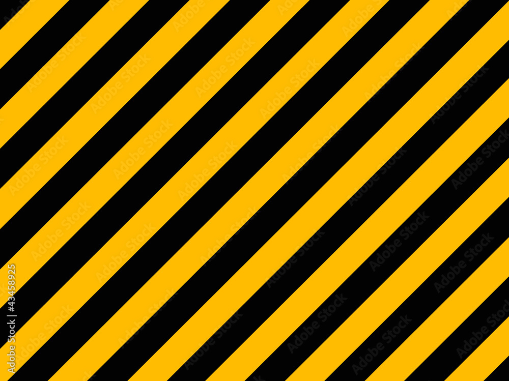 Yellow and black diagonal hazard stripes painted on old brick wa