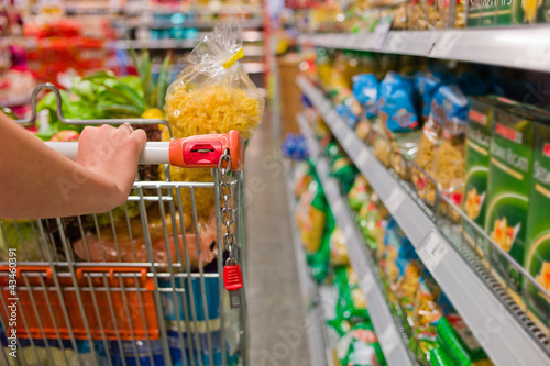 Frau mit Einkaufswagen im Supermarkt photo