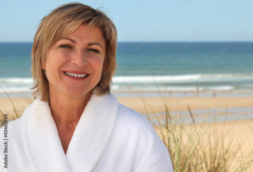 Woman with a bathrobe on the beach Woman with a bathrobe on the beach