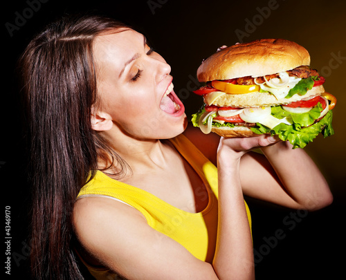 Woman bite hamburger.