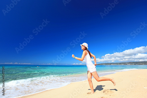 ビーチを走る笑顔の女性