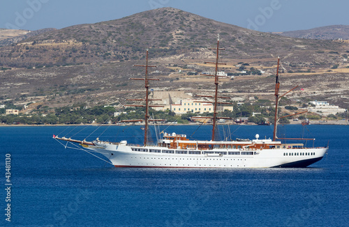 A large sail cruiser anchored off the coast of a Greek island